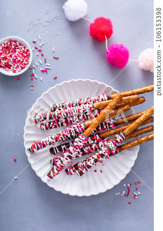 Valentines day treat, chocolate covered pretzel rods with sprinkles Valentines day treat, chocolate covered pretzel rods with sprinkles 106153398