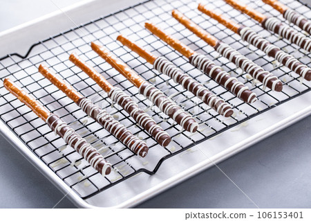 Chocolate covered pretzel rods freshly made on a cooling rack 106153401