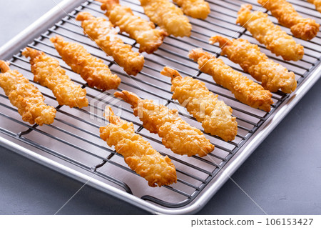 Tempura shrimp just cooked on a cooling rack 106153427