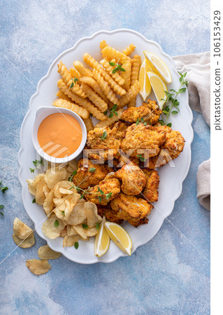 Fish and chips on a serving platter with dipping sauce Fish and chips on a serving platter with dipping sauce 106153429