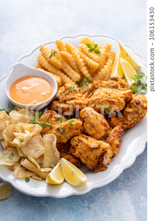 Fish and chips on a serving platter with dipping sauce Fish and chips on a serving platter with dipping sauce 106153430