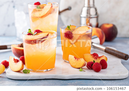 Refreshing summer cocktail with peach and raspberry 106153467