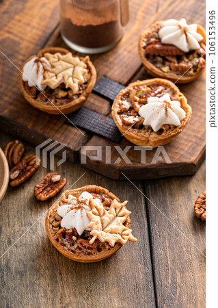 Mini pecan pies baked in a muffin tin Mini pecan pies baked in a muffin tin 106153496