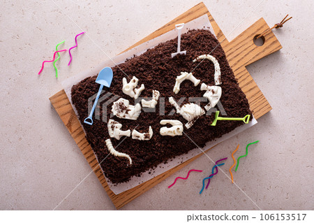Chocolate cake with dinosaur bones for a child birthday Chocolate cake with dinosaur bones for a child birthday 106153517