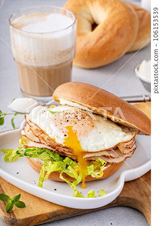 Turkey bagel breakfast sandwich with lettuce and fried egg 106153539