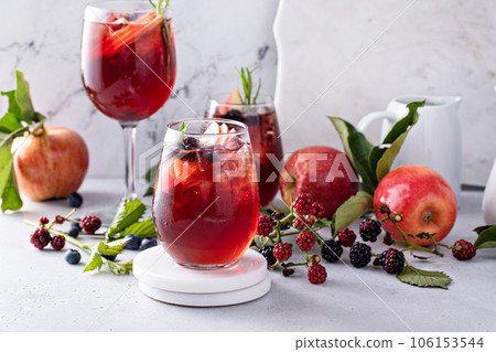 Fall berry and apple sangria in a glass with ice Fall berry and apple sangria in a glass with ice 106153544