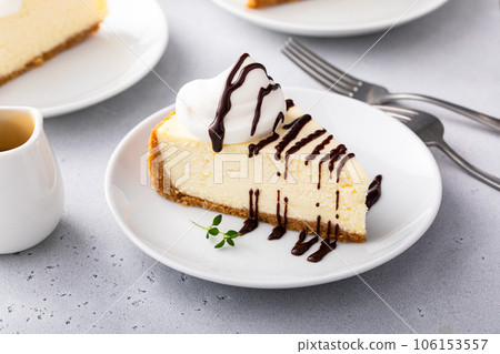 Slice of a traditional New York cheesecake with whipped cream Slice of a traditional New York cheesecake with whipped cream 106153557