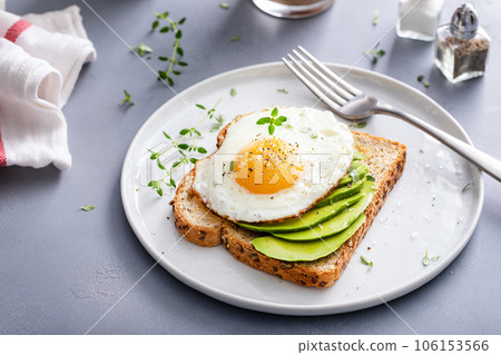 Avocado toast on a toasted multigrain bread with a fried egg 106153566