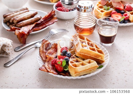 Breakfast table with waffles, croissants and bacon 106153568