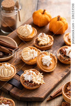 Mini pumpkin and pecan pies baked in muffin tin 106153598