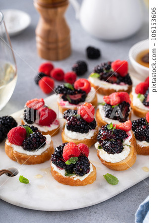 Berry and goat cheese bruschetta with mint and honey Berry and goat cheese bruschetta with mint and honey 106153606