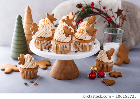 Gingerbread cupcakes with cream cheese frosting topped with gingerbread cookies Gingerbread cupcakes with cream cheese frosting topped with gingerbread cookies 106153725