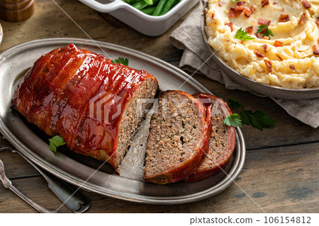 Bacon wrapped meatloaf sliced on a serving plate 106154812