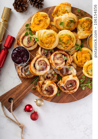Christmas appetizers, puff pastry wheels filled with cheese and jam Christmas appetizers, puff pastry wheels filled with cheese and jam 106154856