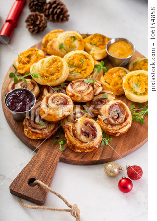 Christmas appetizers, puff pastry wheels filled with cheese and jam Christmas appetizers, puff pastry wheels filled with cheese and jam 106154858