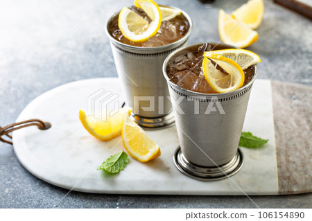 Lemon mint julep cocktail in traditional glasses Lemon mint julep cocktail in traditional glasses 106154890