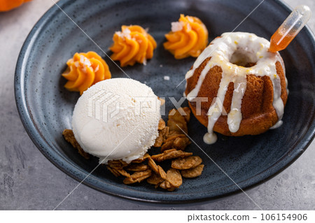 Pumpkin bundt cake soaked with rum served with ice cream 106154906