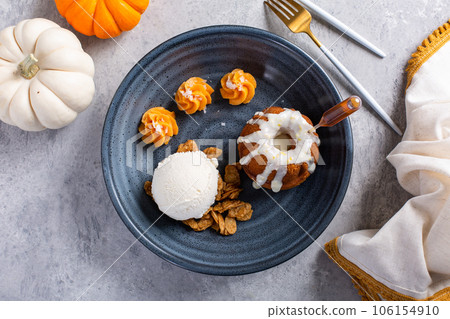 Pumpkin bundt cake soaked with rum served with ice cream 106154910