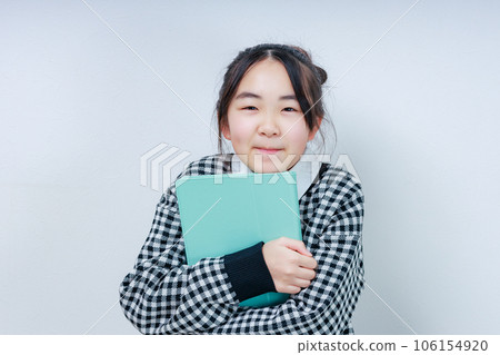 拿著平板電腦並對著鏡頭微笑的女孩 拿著平板電腦並對著鏡頭微笑的女孩 106154920