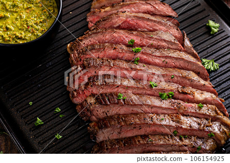 Seared flank steak on a grill pan with chimichurri and horseradish 106154925