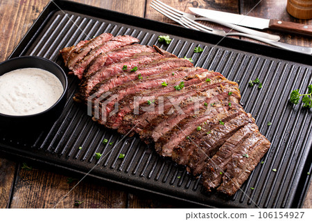 Grilled flank steak with horseradish sauce on a grill pan Grilled flank steak with horseradish sauce on a grill pan 106154927