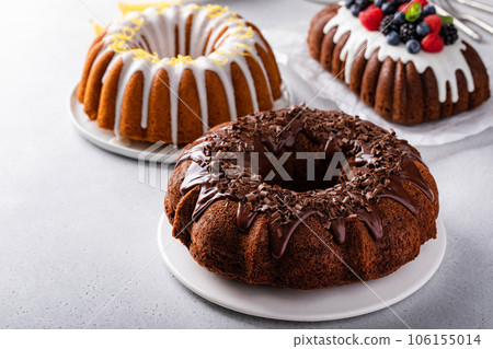 Variety of bundt cakes on the table with lemon, chocolate and berry 106155014