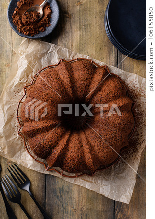 Chocolate bundt cake dusted with cocoa powder 106155050