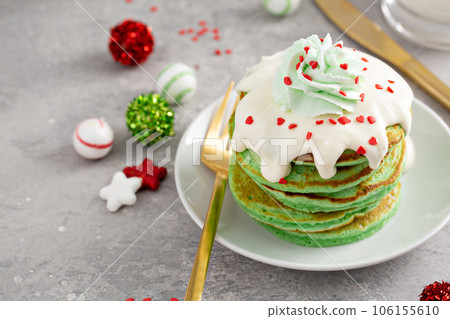 Green pancakes served with white glaze and whipped cream Green pancakes served with white glaze and whipped cream 106155610