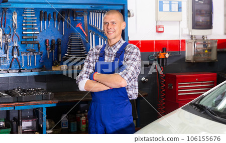 Professional auto mechanic posing in workshop 106155676