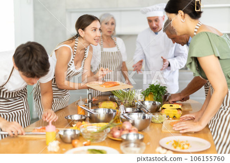 Young woman talking with participants at group culinary class Young woman talking with participants at group culinary class 106155760