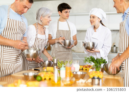 Young female cook teaches to cook group of people 106155803
