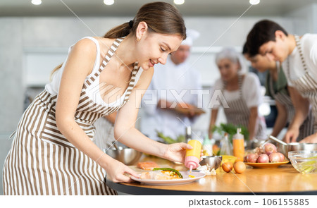 Chef apprentices learn how to cook delicious salmon fillet with asparagus and gravy together in cooking class 106155885