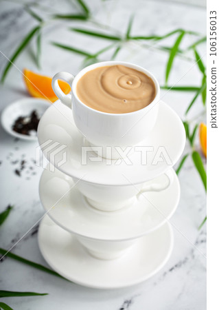 Earl grey milk tea poured in stacked cups Earl grey milk tea poured in stacked cups 106156013