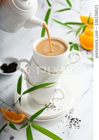 Earl grey milk tea poured in stacked cups 106156021