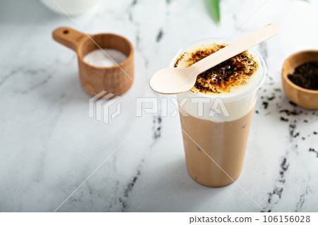 Creme bruleed iced coffee or tea with milk foam topping 106156028