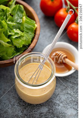 Homemade honey mustard dressing in a glass jar Homemade honey mustard dressing in a glass jar 106156047