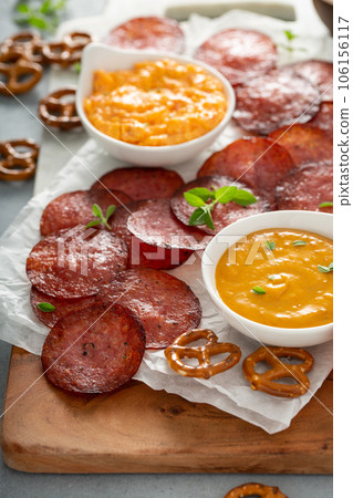 Salami chips baked in the oven with cheese sauces 106156117