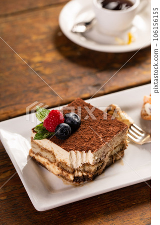Traditional italian desserts, tiramisu and cannoli on the plate 106156155