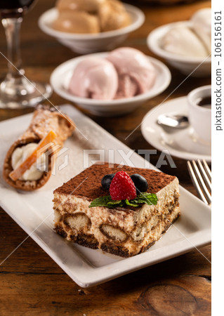 Traditional italian desserts, tiramisu and cannoli on the plate Traditional italian desserts, tiramisu and cannoli on the plate 106156161