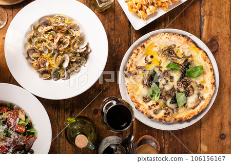 Pizza and pasta on wooden table with wine 106156167