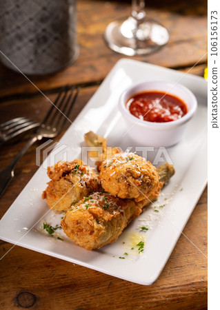 Fried lamb chops in parmesan batter with tomato sauce Fried lamb chops in parmesan batter with tomato sauce 106156173