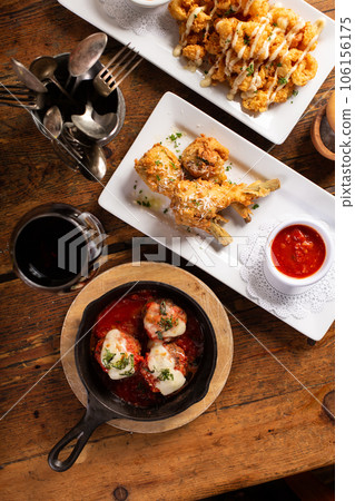 Baked meatballs in marinara sauce with cheese and basil 106156175