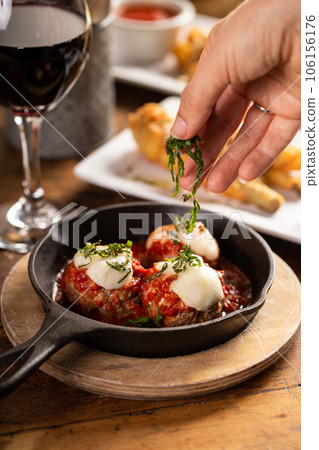 Italian meatballs served in a cast iron pan 106156176
