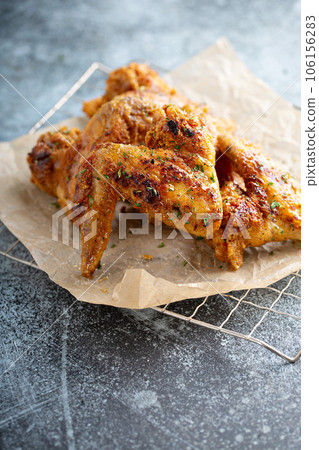 Southern fried chicken wings with honey on parchment 106156283