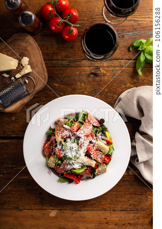 Italian antipasto salad with salami, artichoke hearts and olives 106156288