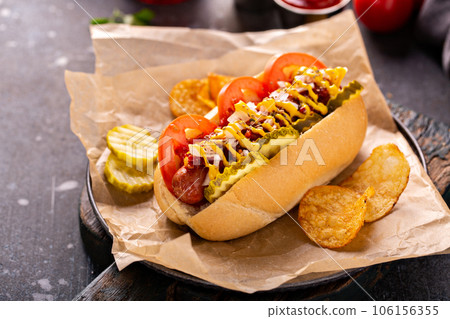 Hot dog with tomatoes, mustard and pickles 106156355