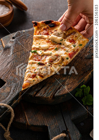 Bacon and sausage pizza on dark background 106156383