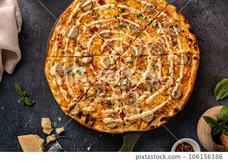 Bacon and sausage pizza on dark background Bacon and sausage pizza on dark background 106156386