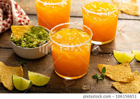 Pineapple and mango margarita with chips and guacamole 106156651