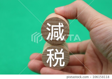 一個人拿著一塊寫著減稅的積木 一個人拿著一塊寫著減稅的積木 106158118